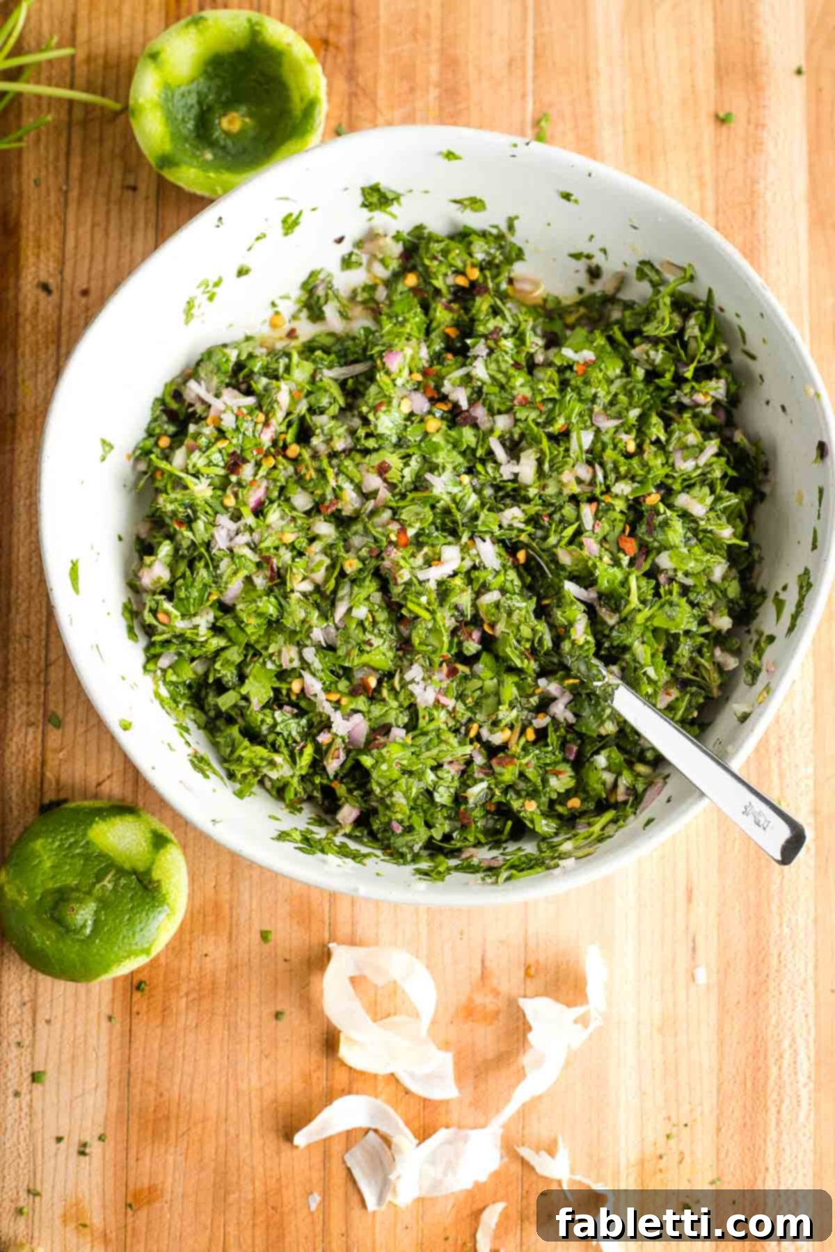 Vibrant Cilantro Chimichurri 8 Bowl of chimichurri, showcasing its vibrant fresh green herbs, speckled with purple onion and crushed red pepper.