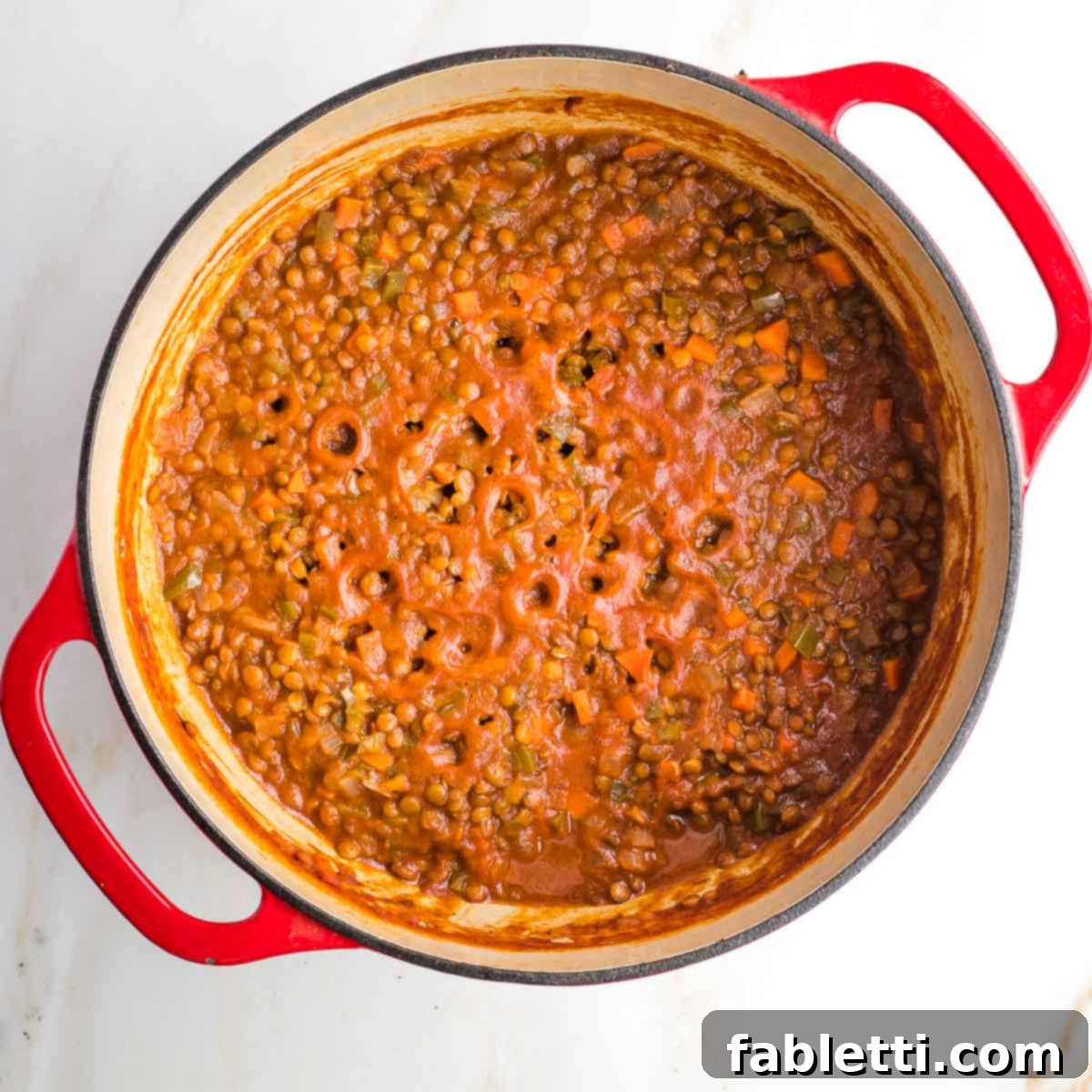 Dutch oven with vegan sloppy joes mixture, holes on top where the sauce evaporated.