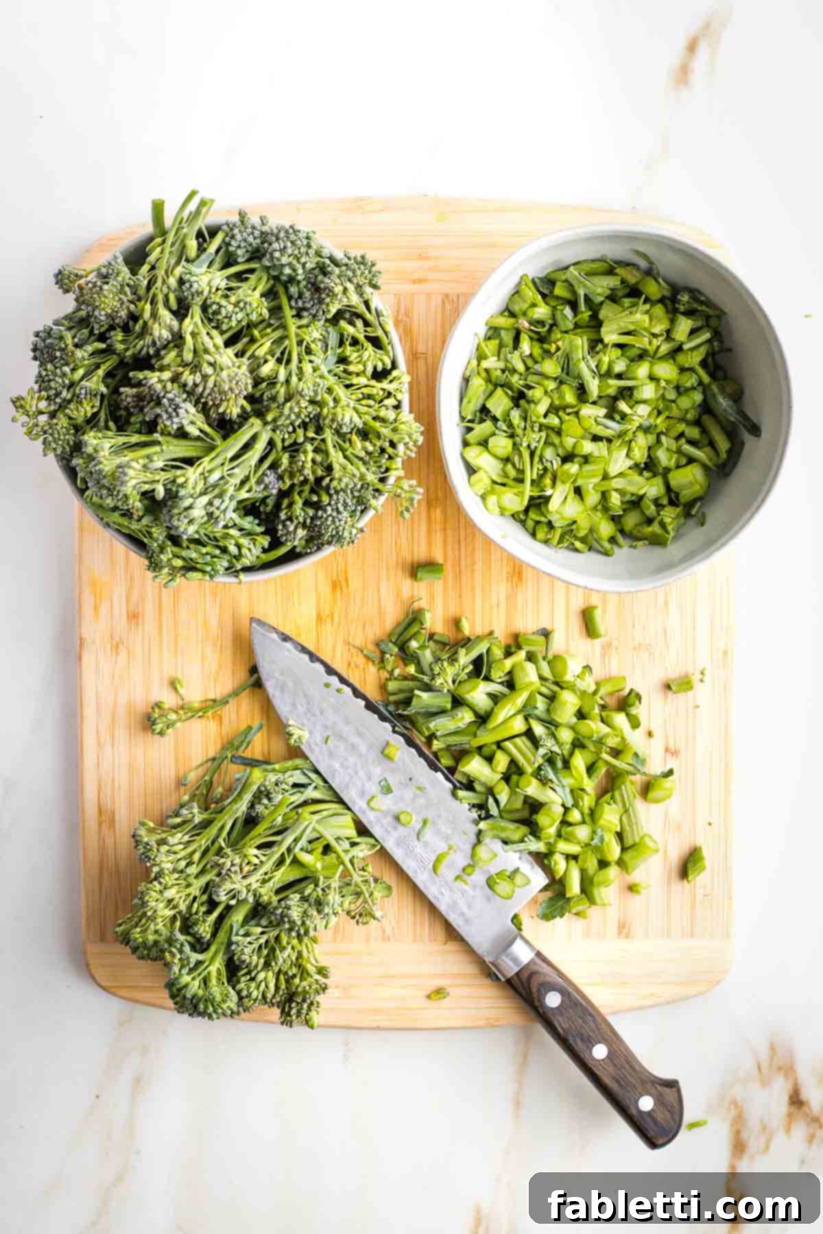 Chopping bottom of broccolini stems off, placing in one bowl and the florets in another.