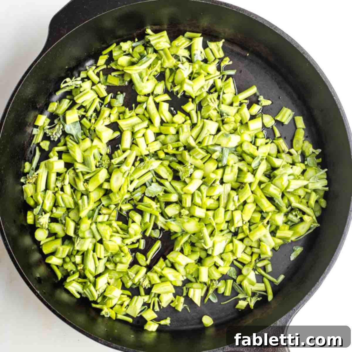 Sliced broccolini stems in a cast iron skillet.