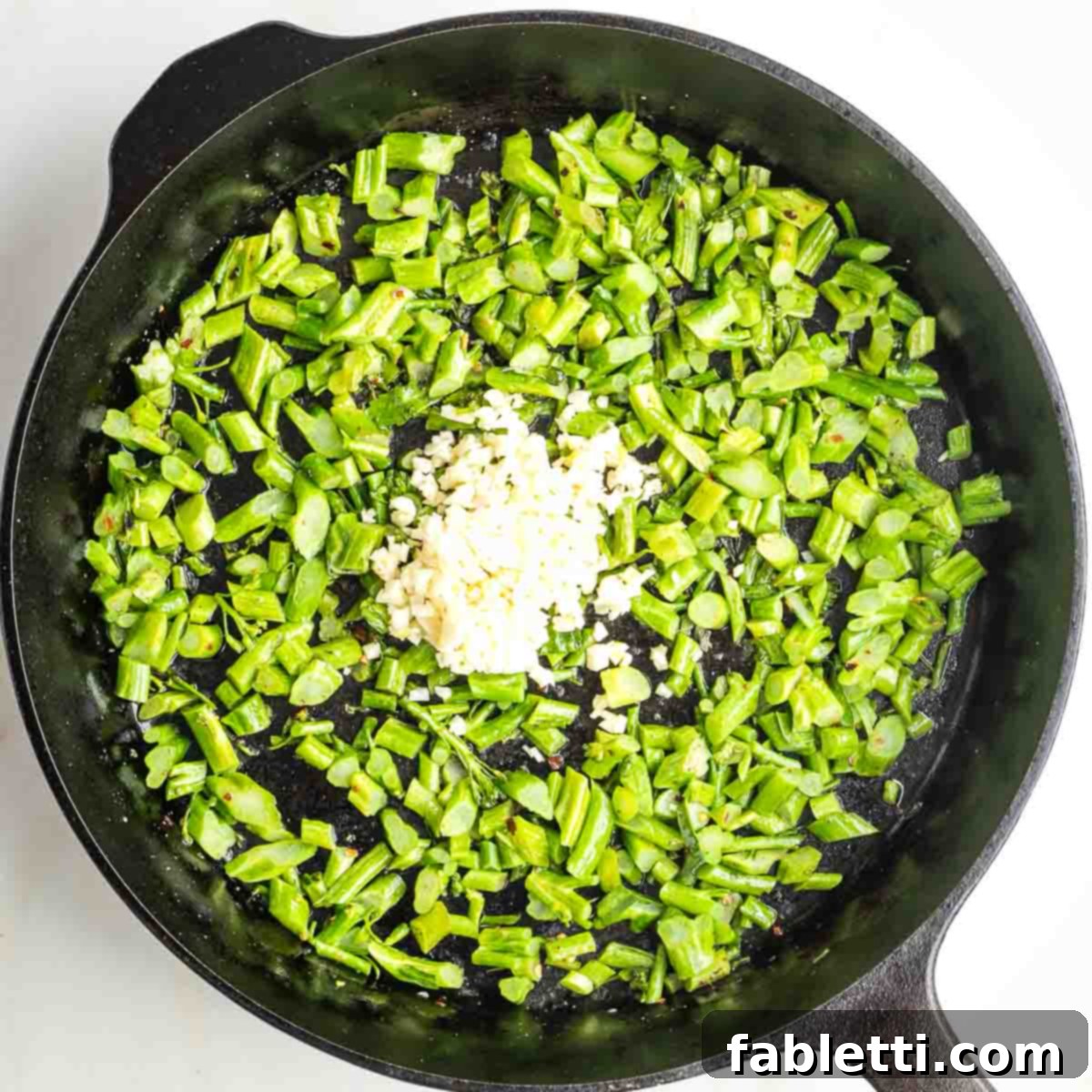 Sauteed broccolini stems in a cast iron with a couple tablespoons minced garlic in the middle.