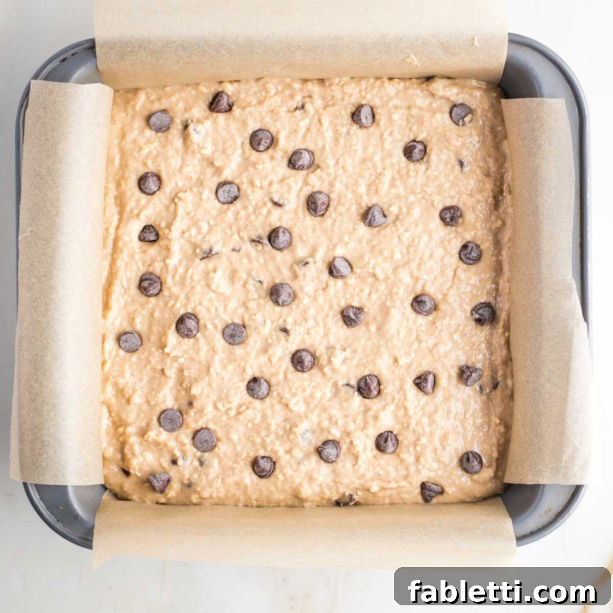 Bean-Powered Vegan Blondies 11 Square baking pan filled with blondies batter with chocolate chips.