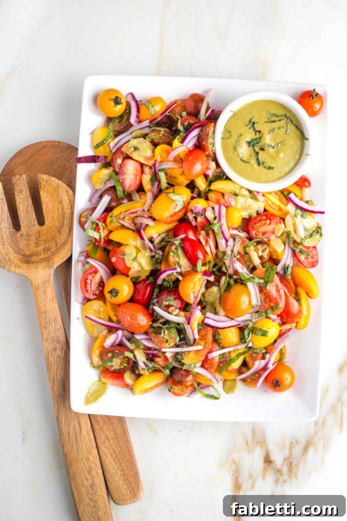Sun-Kissed Tomato and Onion Salad with Balsamic Drizzle 2 Bright and colorful tomatoes with red onion, fresh basil on a platter with a small bowl of creamy dressing.