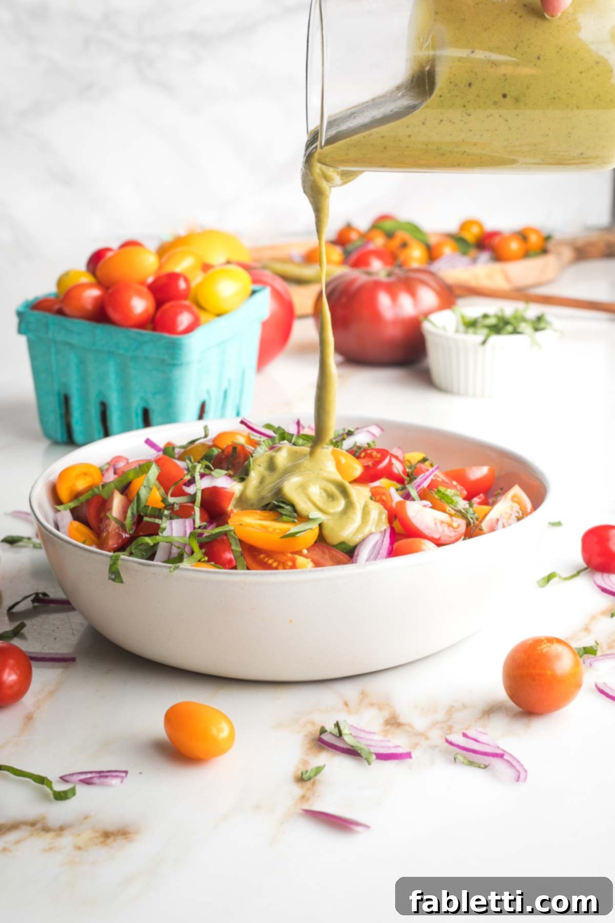 Sun-Kissed Tomato and Onion Salad with Balsamic Drizzle 7 Creamy basil dressing poured over a bowl of chopped tomatoes, onions and basil.