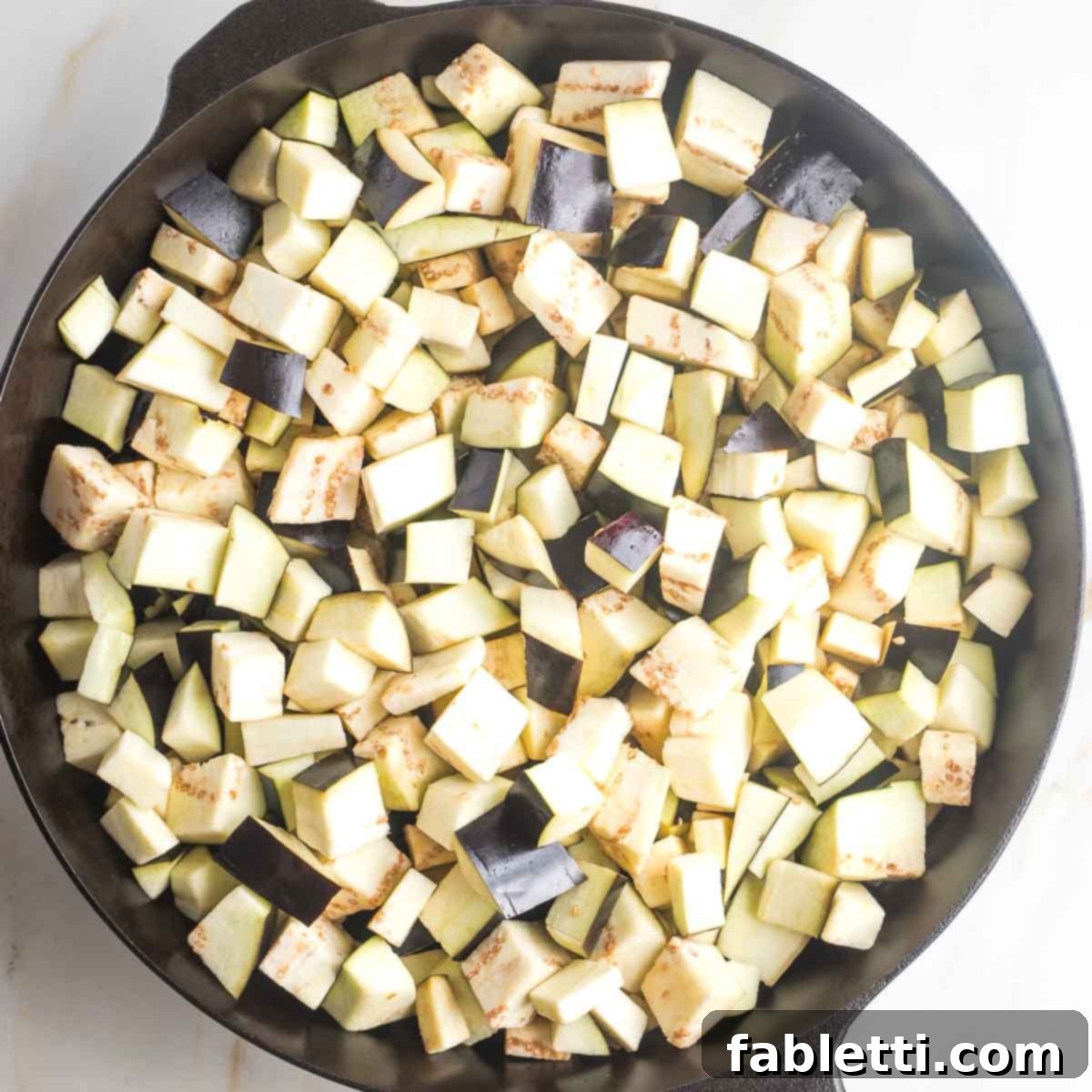 Savory Sautéed Eggplant Salad 10 Small cubes of eggplant cooking in a cast iron skillet with olive oil.