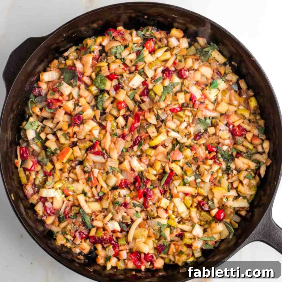 Skillet with sautéed vegetables and fruits, now with fresh chopped sage stirred in.