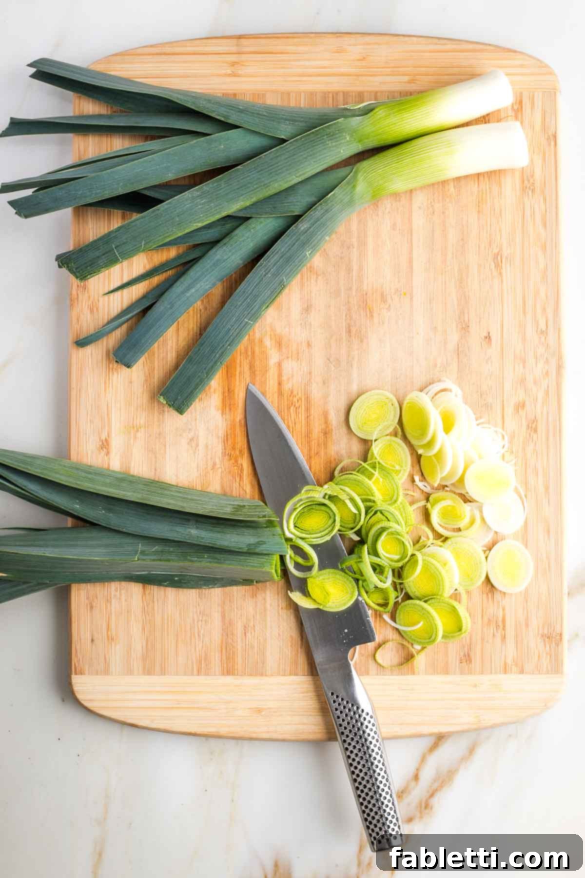 Leeks being sliced thin, through the white part and some of the light green.