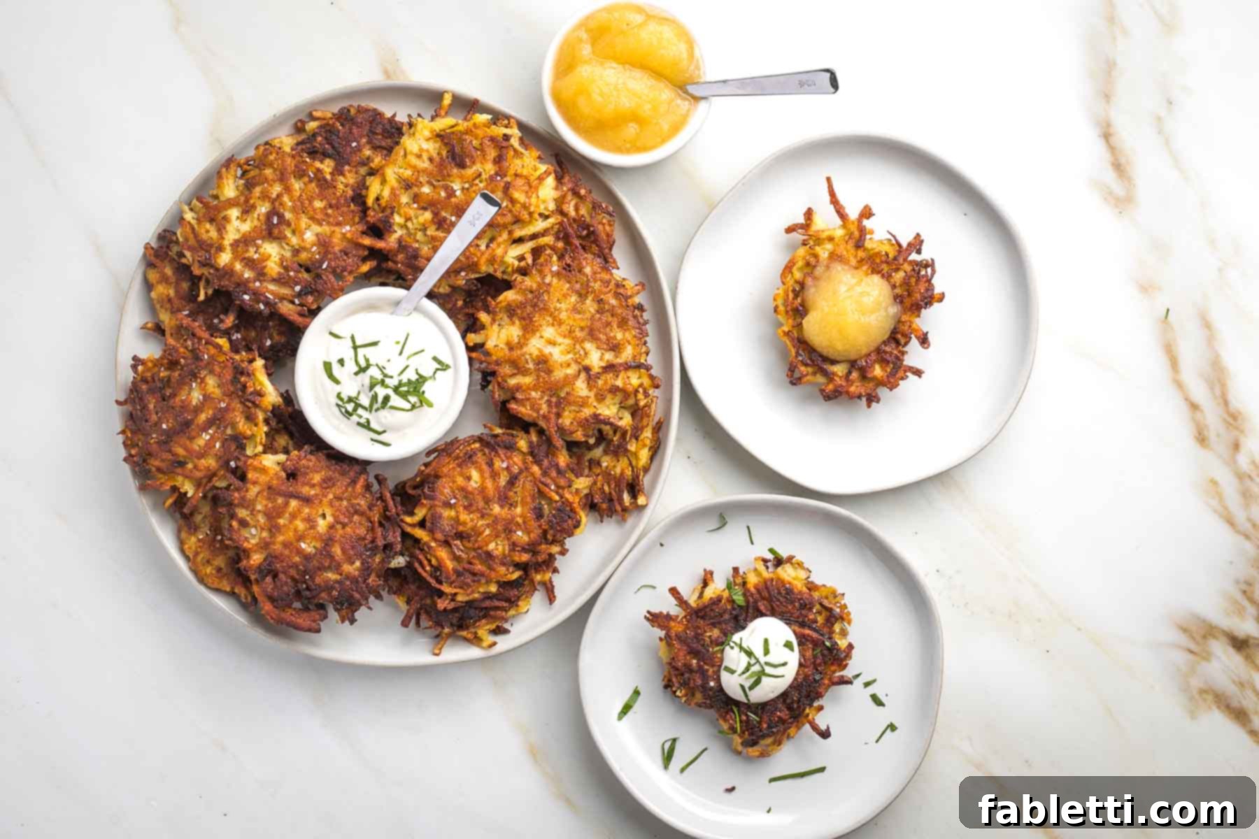 Grandma's Golden Potato Latkes 15 A festive platter of golden-brown latkes, with a central bowl of sour cream and a smaller dish of applesauce, ready for serving.