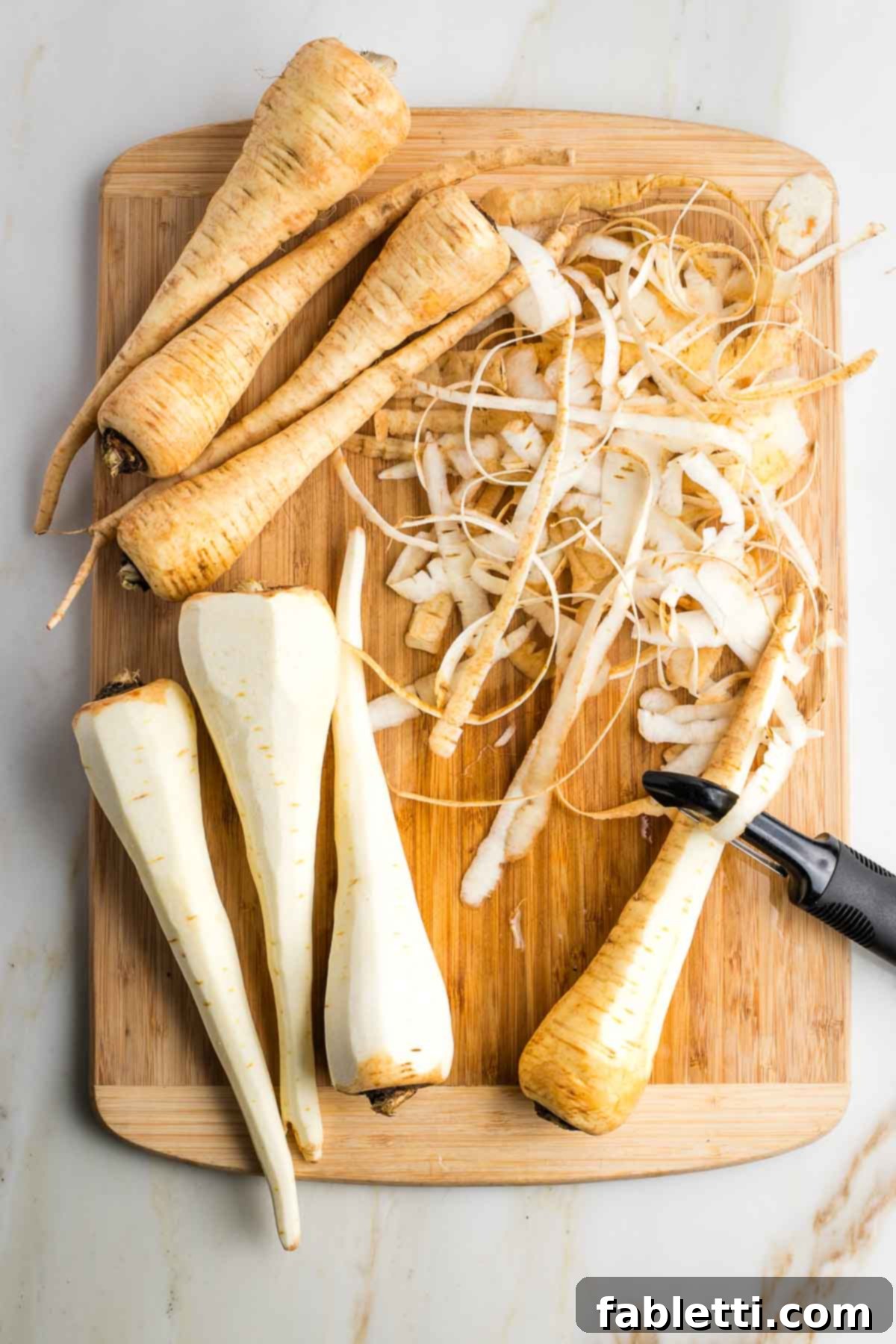 Luscious Vegan Parsnip Gratin 13 Parsnips on a cutting board, some peeled, some not.