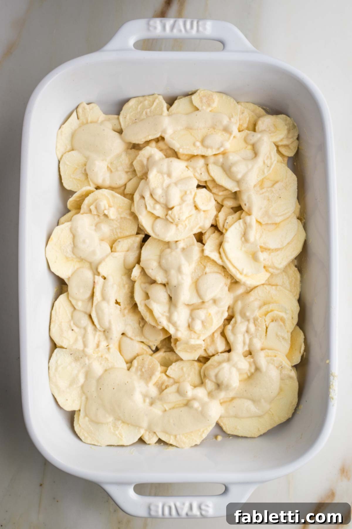 Luscious Vegan Parsnip Gratin 17 Layers of sliced parsnips in a casserole dish.