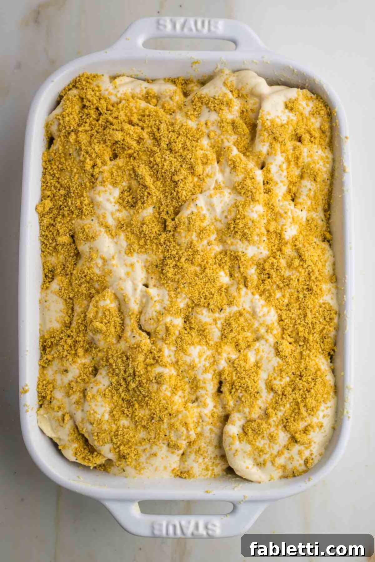 Luscious Vegan Parsnip Gratin 20 Thinly sliced parsnips with sauce and parmesan sprinkled on top.