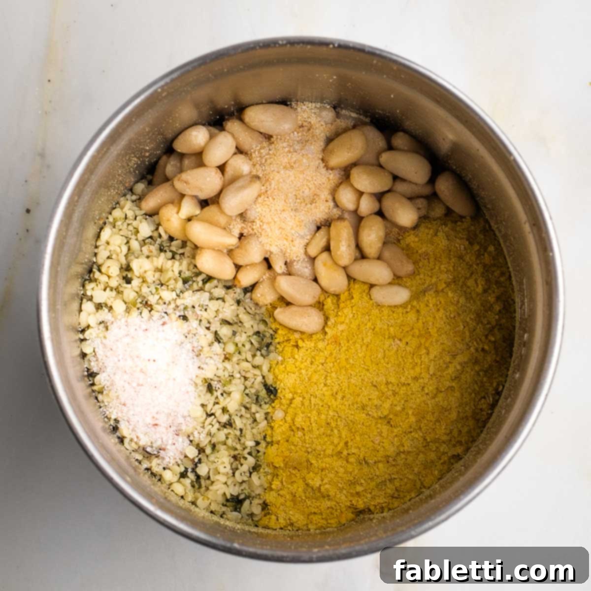 Luscious Vegan Parsnip Gratin 10 Spice grinder cup filled with hemp seeds, pine nuts, nutritional yeast and spices.