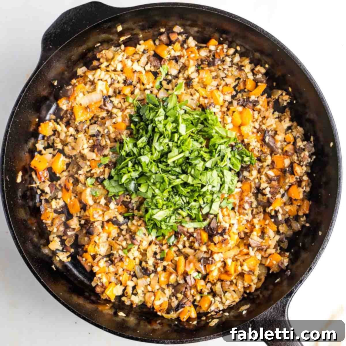 Gourmet Vegan Stuffed Portobello Mushrooms 13 Sautéed small diced vegetables with a heap of chopped greens in the center of the pan, ready to be mixed.