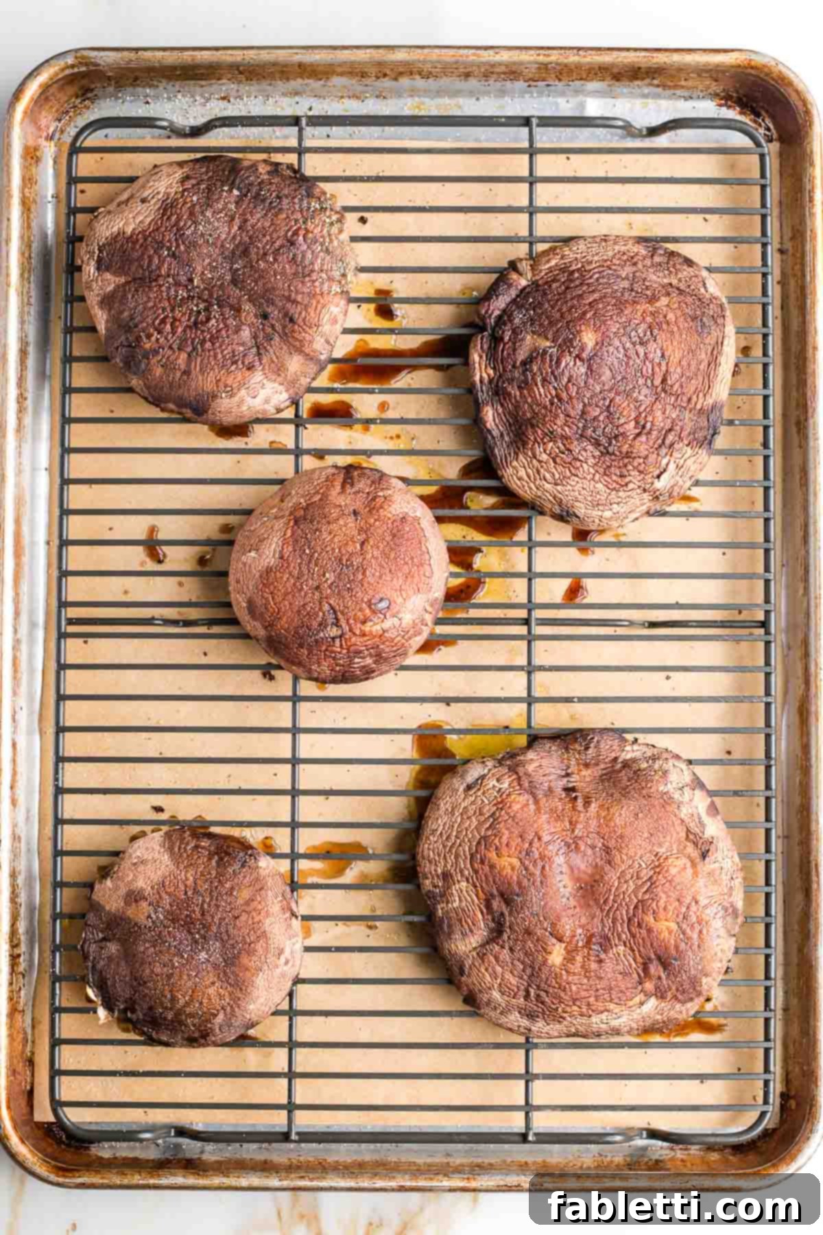 Gourmet Vegan Stuffed Portobello Mushrooms 8 Large portobello mushroom caps inverted on a wire rack on a baking tray, showing the initial baking setup.