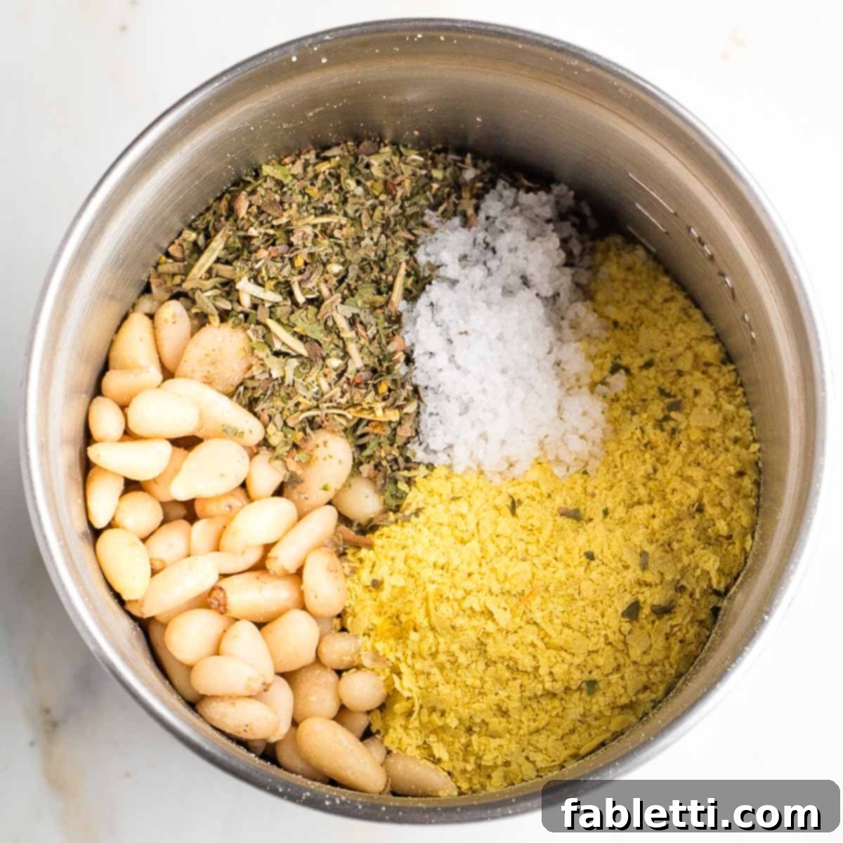 Gourmet Vegan Stuffed Portobello Mushrooms 9 Pine nuts, Italian seasoning, salt, and nutritional yeast in the bowl of a spice grinder, ready to be processed.