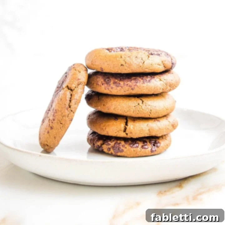 Plant-Powered Tahini Dishes 3 Stack of cookies with some melted chocolate sprinkles and one leaning against the stack.