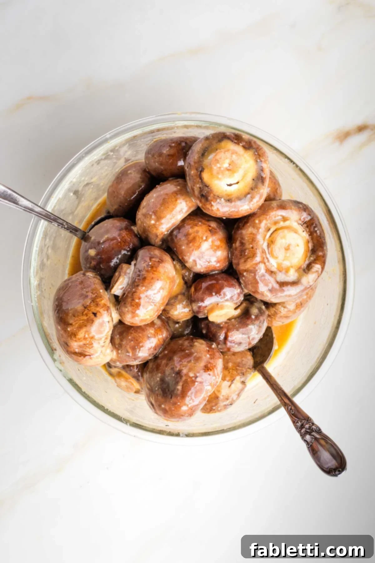 Umami-Rich Vegan Miso Mushrooms 7 Mushrooms coated in miso sauce, marinating in a bowl.