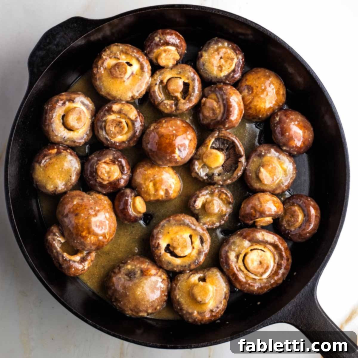 Umami-Rich Vegan Miso Mushrooms 9 Mushrooms cooking in a cast iron skillet.