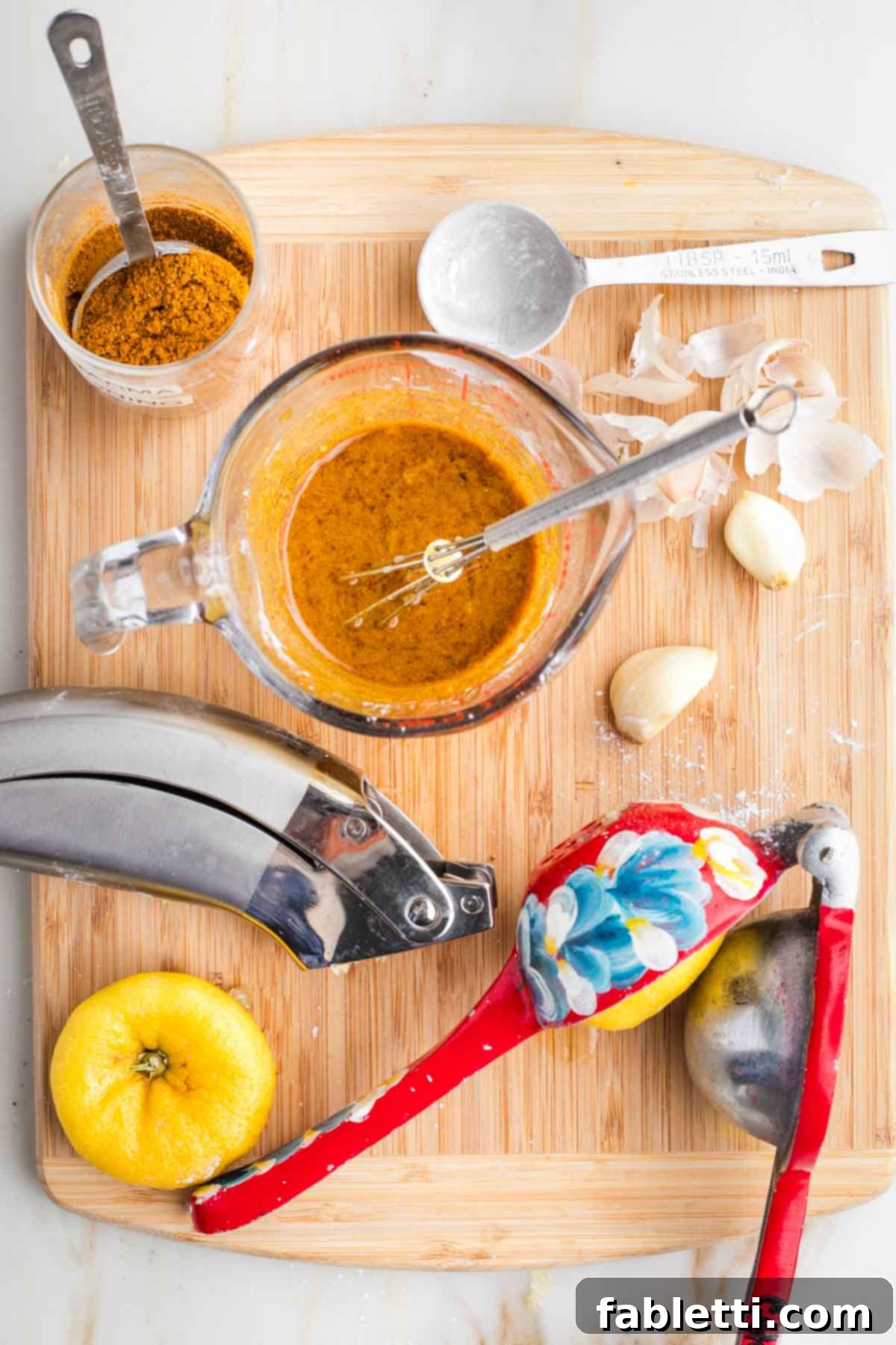 Flavorful Vegan Tofu Shawarma 6 Close-up view of a small bowl where olive oil, lemon juice, pressed garlic, and various shawarma spices are being whisked together to form a smooth marinade.