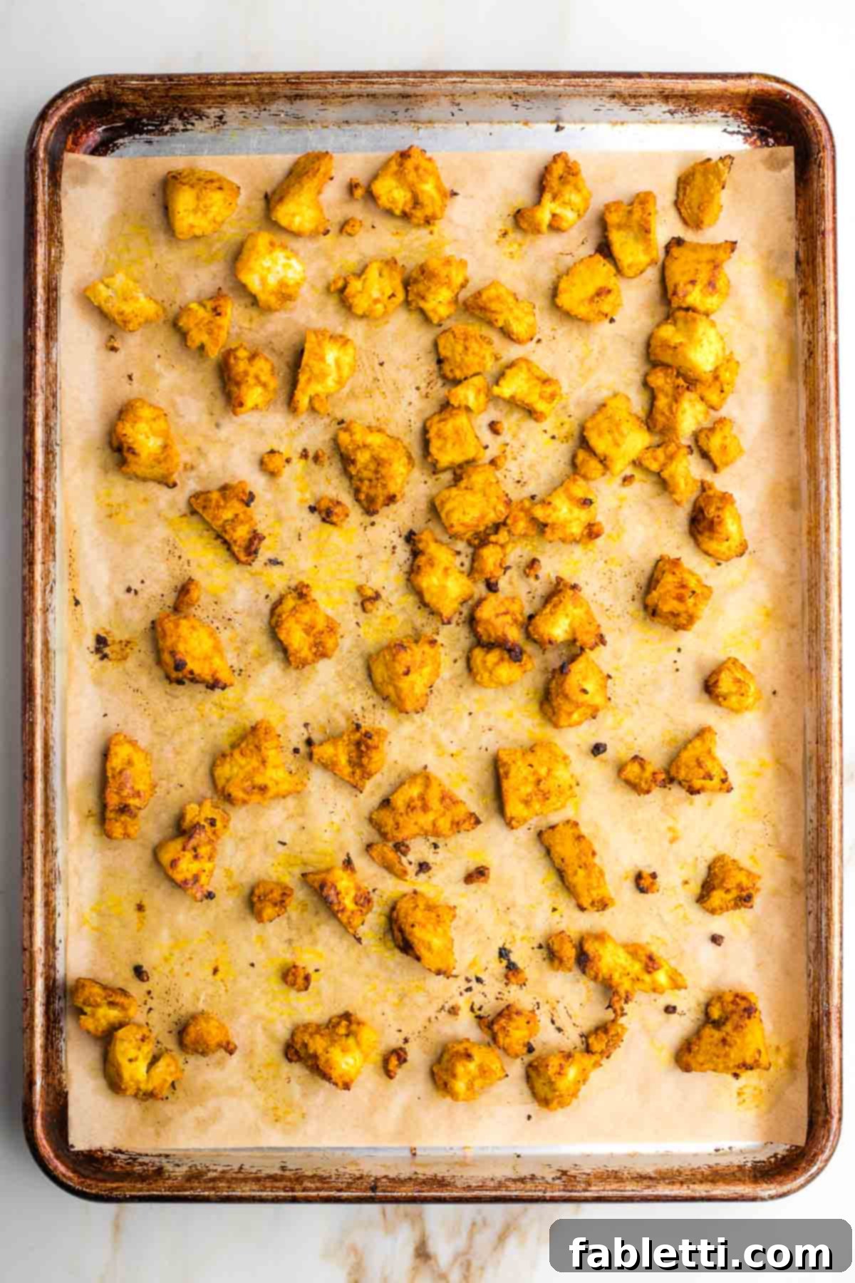 Flavorful Vegan Tofu Shawarma 9 The marinated tofu pieces, evenly spread in a single layer on a baking sheet, ready for roasting in the oven.