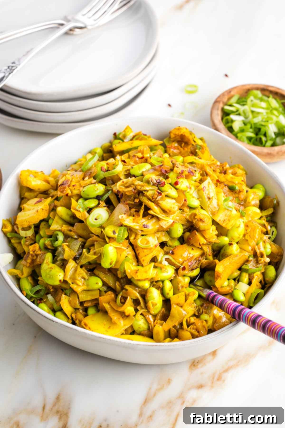 Speedy Skillet Curried Cabbage 2 A beautifully plated bowl of Cabbage Curry with edamame, garnished with fresh herbs.