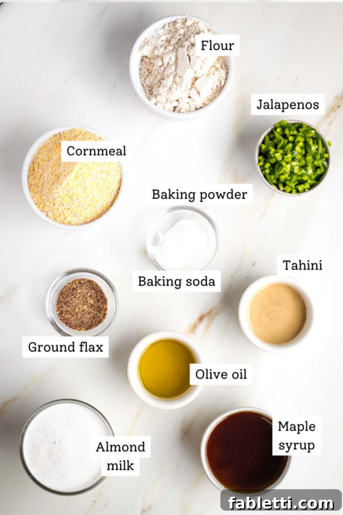 Spicy Vegan Skillet Jalapeño Cornbread 3 Labeled ingredients: flour, cornmeal, jalapenos, almond milk, maple syrup, tahini, baking powder and soda, ground flax and olive oil.