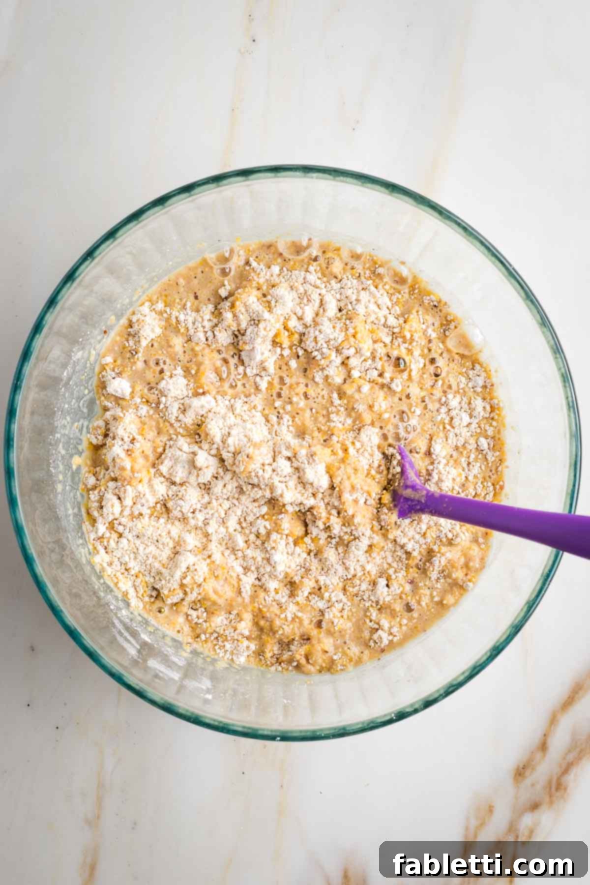 Spicy Vegan Skillet Jalapeño Cornbread 6 Stirring cornbread batter together, mixing the wet ingredients with the dry.