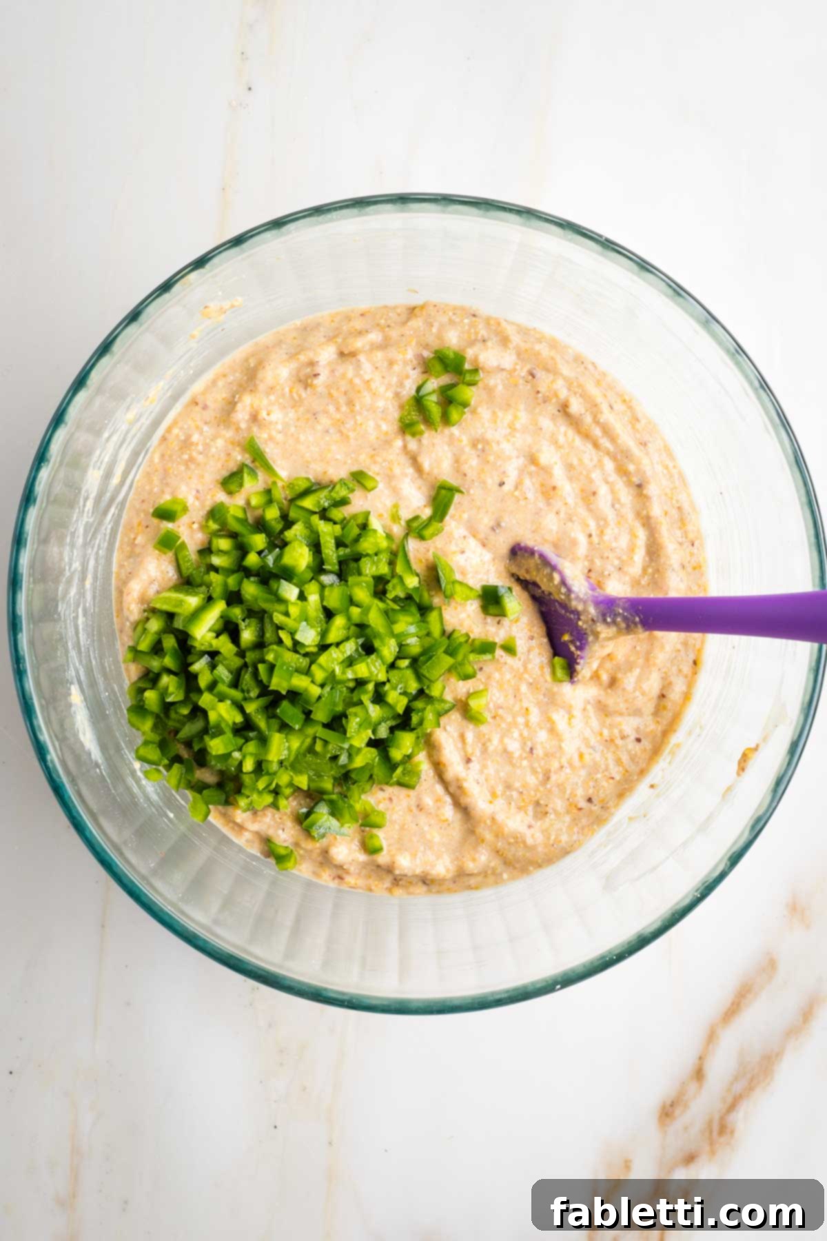 Spicy Vegan Skillet Jalapeño Cornbread 8 Cornbread batter with diced jalapenos on top.