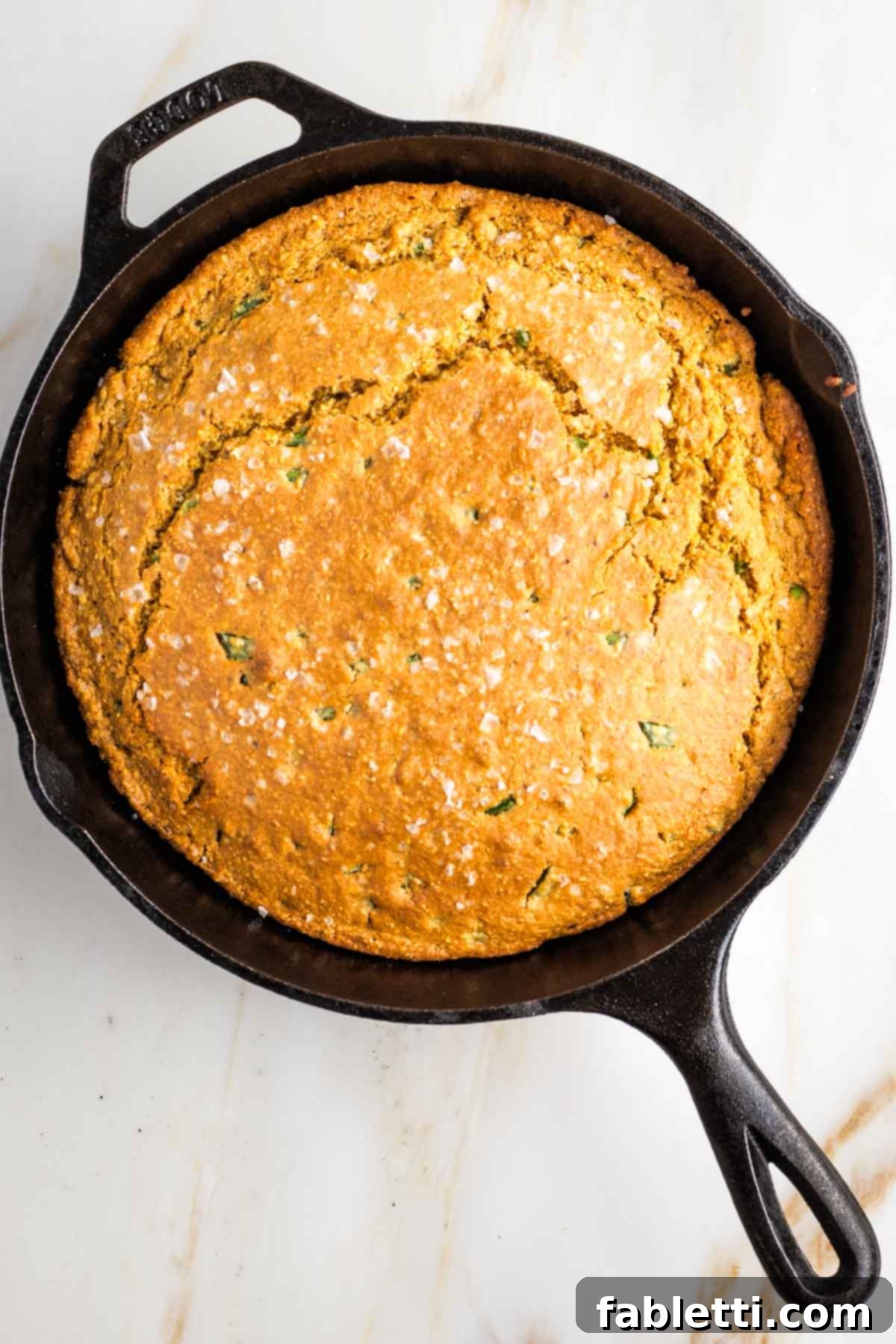 Spicy Vegan Skillet Jalapeño Cornbread 10 Golden brown skillet cornbread with a crack through the top straight across.