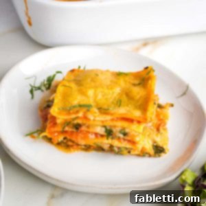 Lush Layers: Gluten-Free Vegan Garden Lasagna 17 Layers of noodles, greens, zucchini, bechamel and marinara shown on a side view of a piece of lasagna.