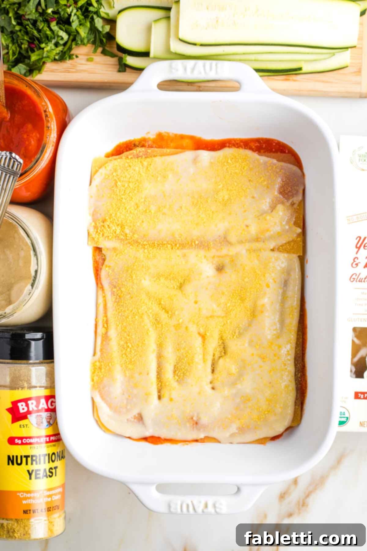 Lush Layers: Gluten-Free Vegan Garden Lasagna 9 Baking dish layered with red sauce, noodles, bechamel and nutritional yeast.
