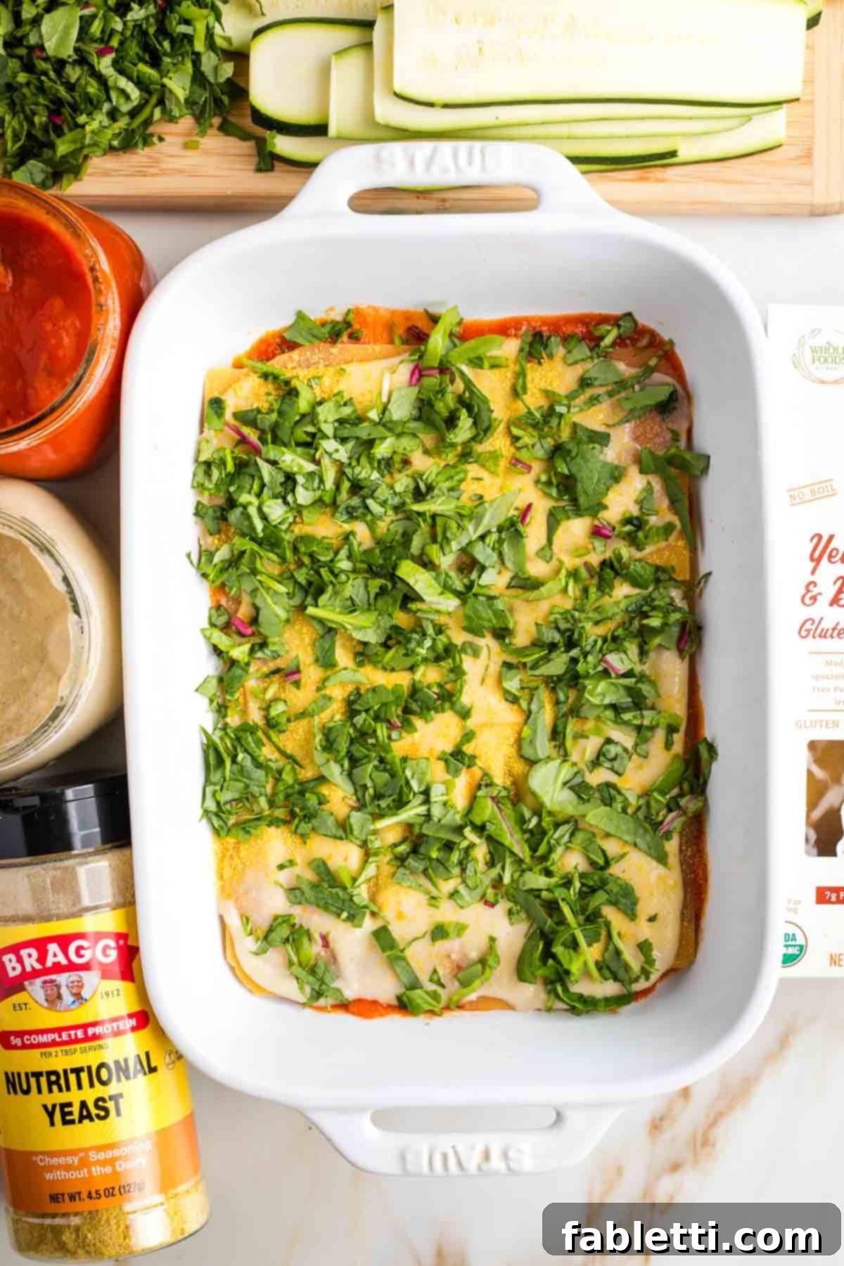 Lush Layers: Gluten-Free Vegan Garden Lasagna 10 Layering a lasagna in a baking dish, chopped greens on top.
