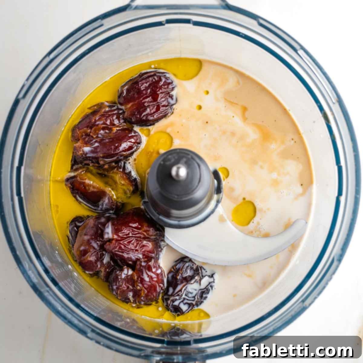 Naturally Sweetened Vegan Pecan Pie Bars 13 Food processor bowl with tahini, oil, dates and maple syrup distinctly visible.