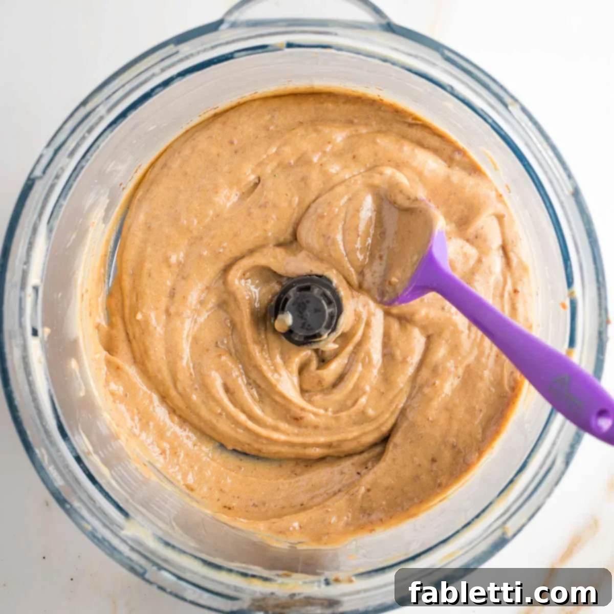 Naturally Sweetened Vegan Pecan Pie Bars 14 Gooey caramel colored paste that looks like frosting in a food processor bowl.