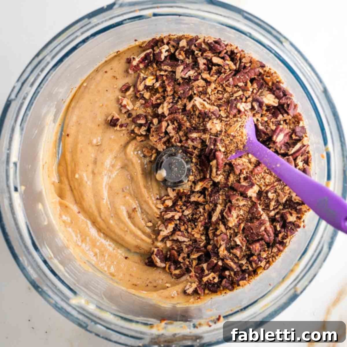 Naturally Sweetened Vegan Pecan Pie Bars 15 Chopped and toasted pecans on top of a caramel spread in the bowl of a food processor.
