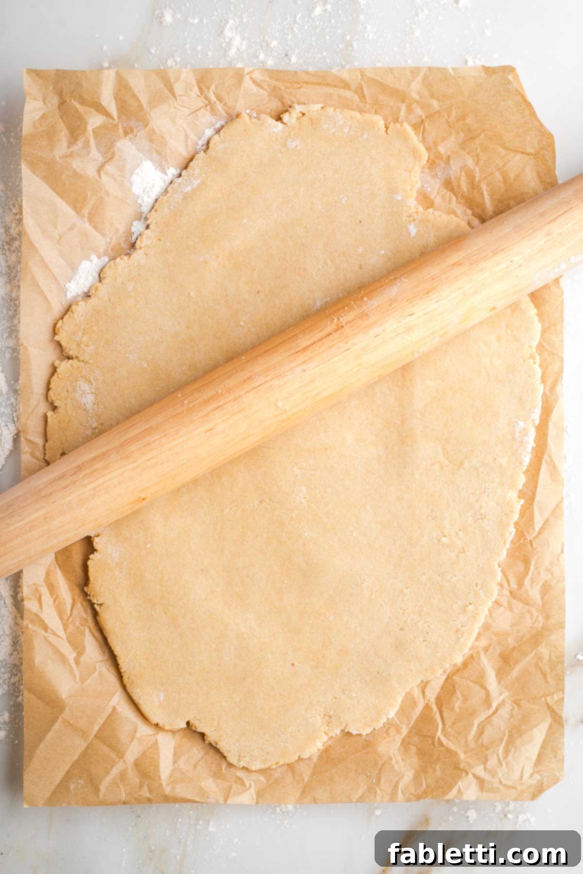 Naturally Sweetened Vegan Pecan Pie Bars 7 Wooden rolling pin, rolling out pie crust on a piece of unbleached parchment paper.