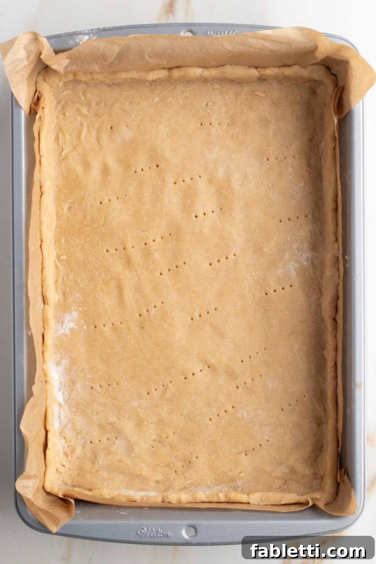 Naturally Sweetened Vegan Pecan Pie Bars 9 Pie crust pressed into rectangular baking dish, with fork pricks.