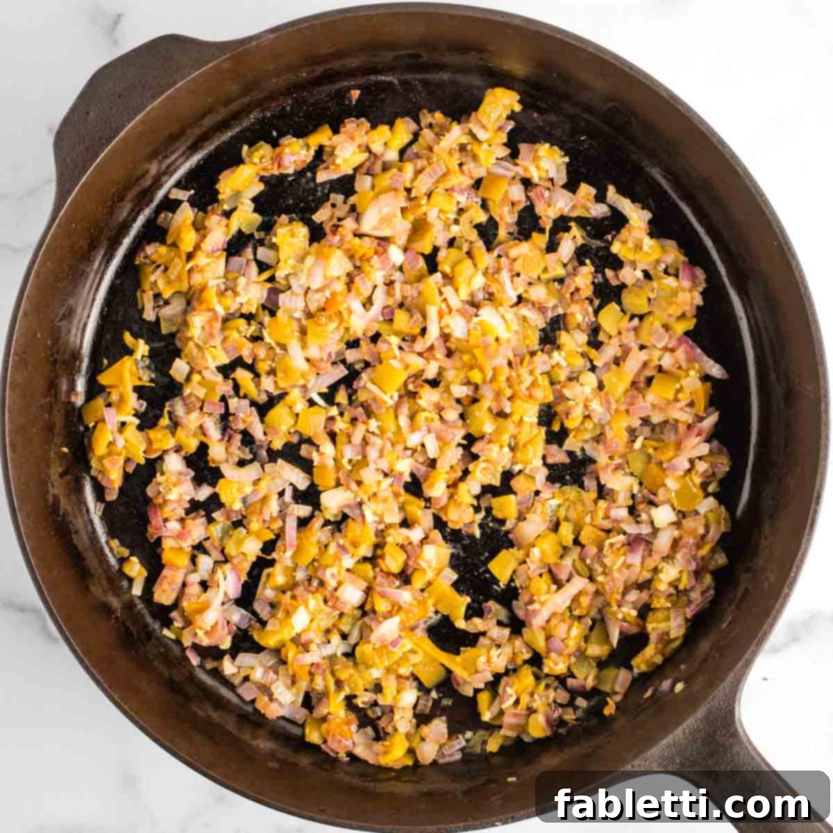 Effortless Skillet Plant-Based BBQ Beans 10 The cast iron skillet now holds a harmonious blend of sautéed onions, aromatic minced garlic, and vibrant green chiles, filling the kitchen with enticing aromas.
