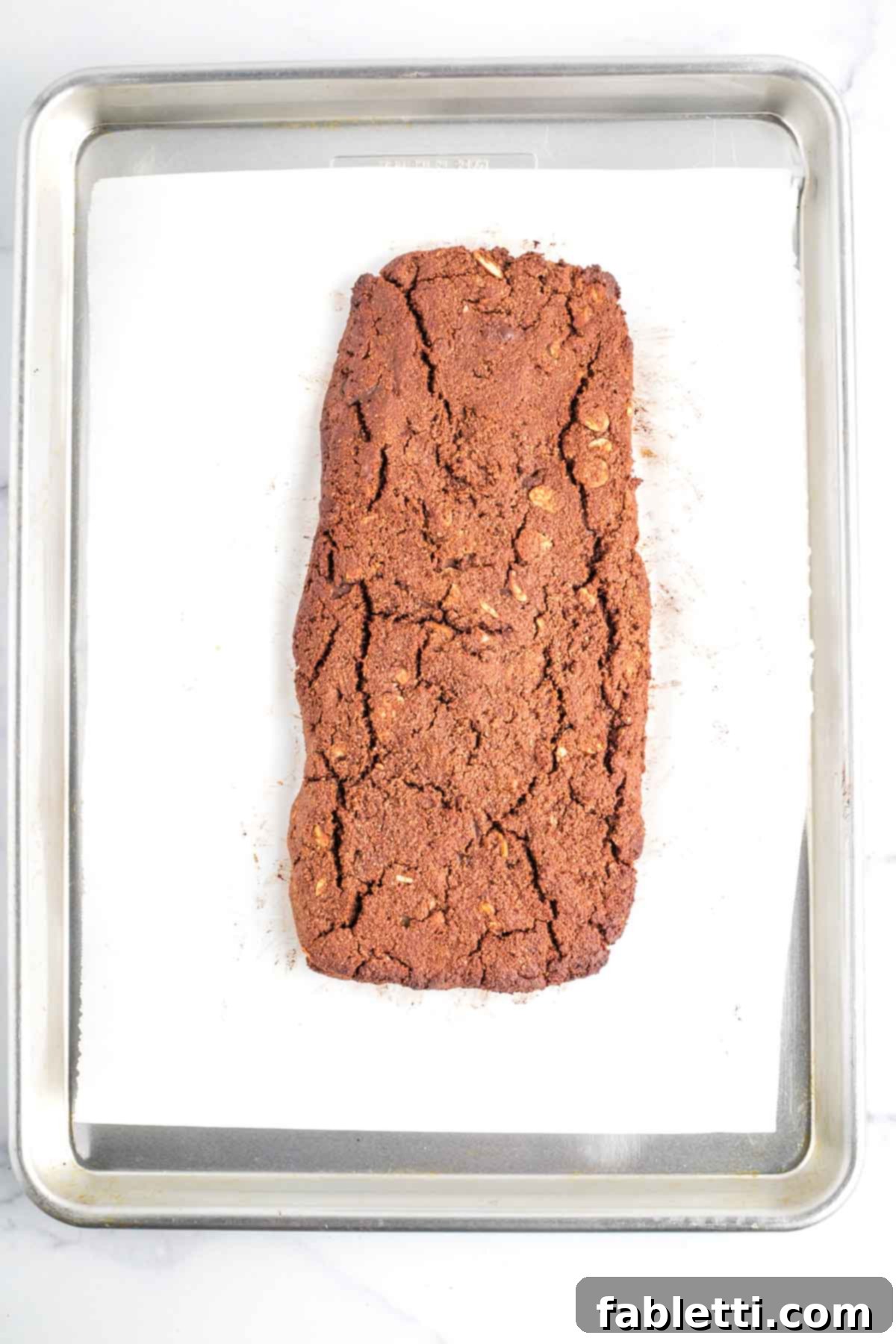 Irresistible Vegan Gluten-Free Chocolate Almond Biscotti 12 Baked loaf of chocolate biscotti, cracked on the top.
