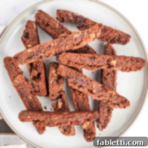 Irresistible Vegan Gluten-Free Chocolate Almond Biscotti 17 Plate full of chocolate biscotti with chocolate chips and almond slivers.