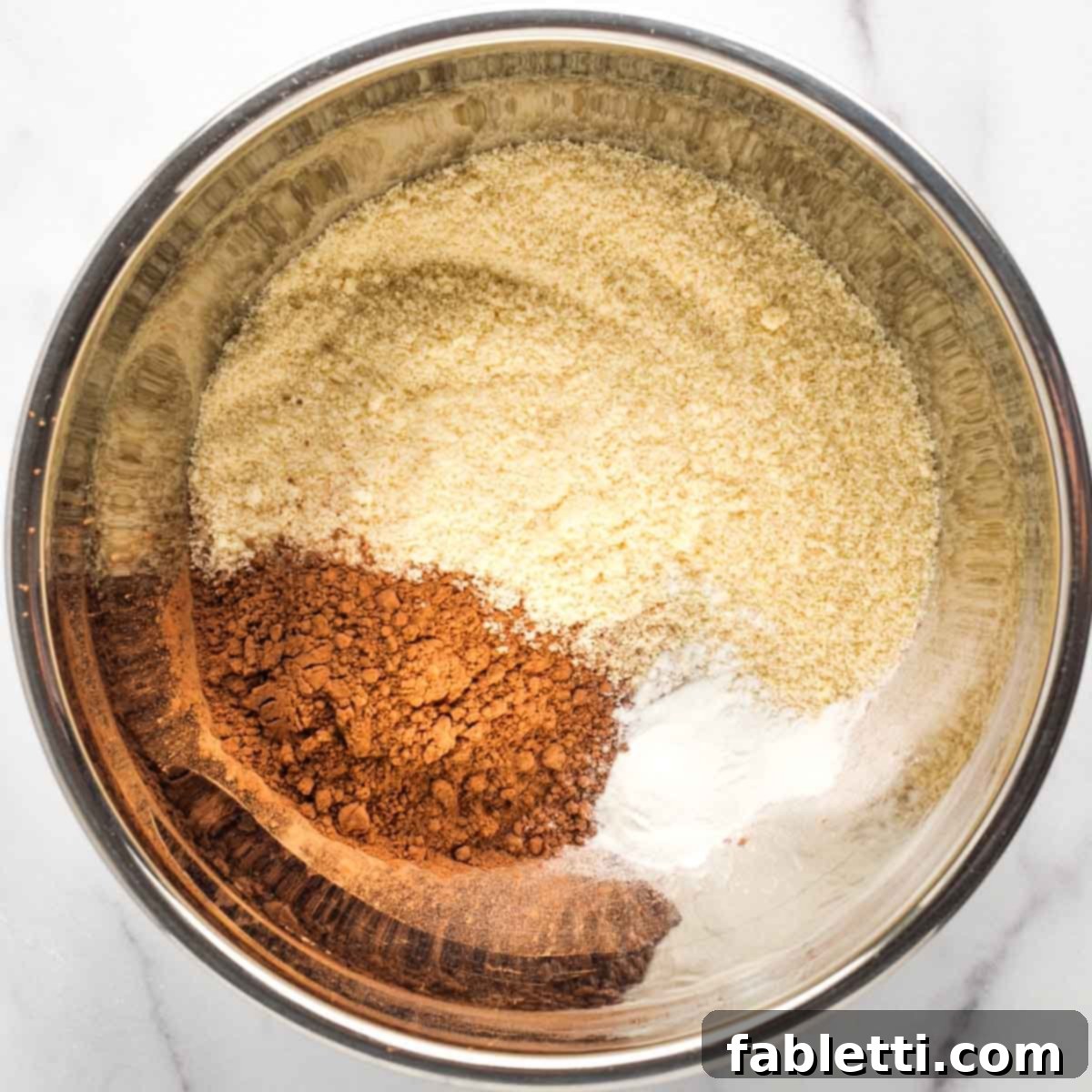 Irresistible Vegan Gluten-Free Chocolate Almond Biscotti 4 Metal mixing bowl with almond flour, cocoa powder and baking powder.