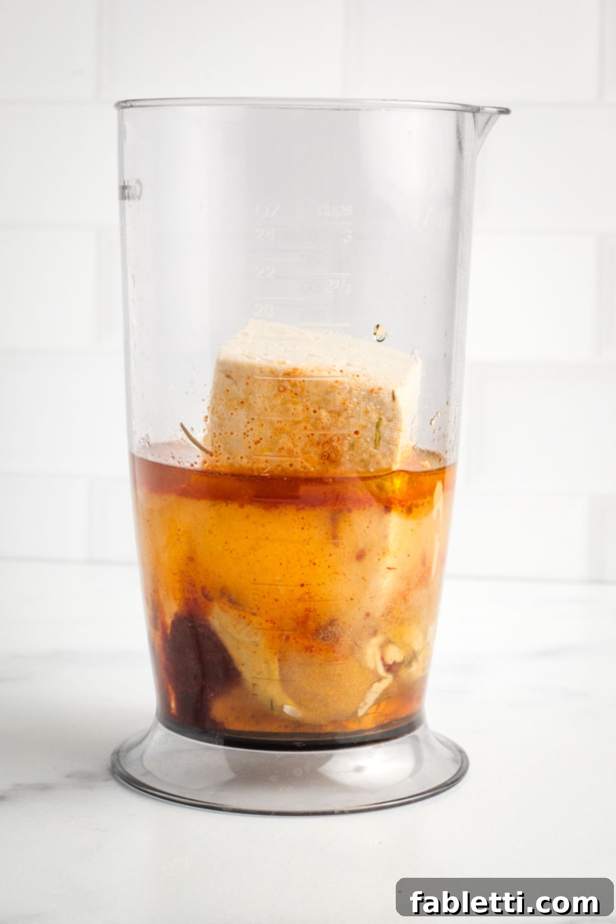 Creamy Tofu Vegan Big Mac Sauce 4 Tall container with block of tofu, plus liquid, spices and mustard.