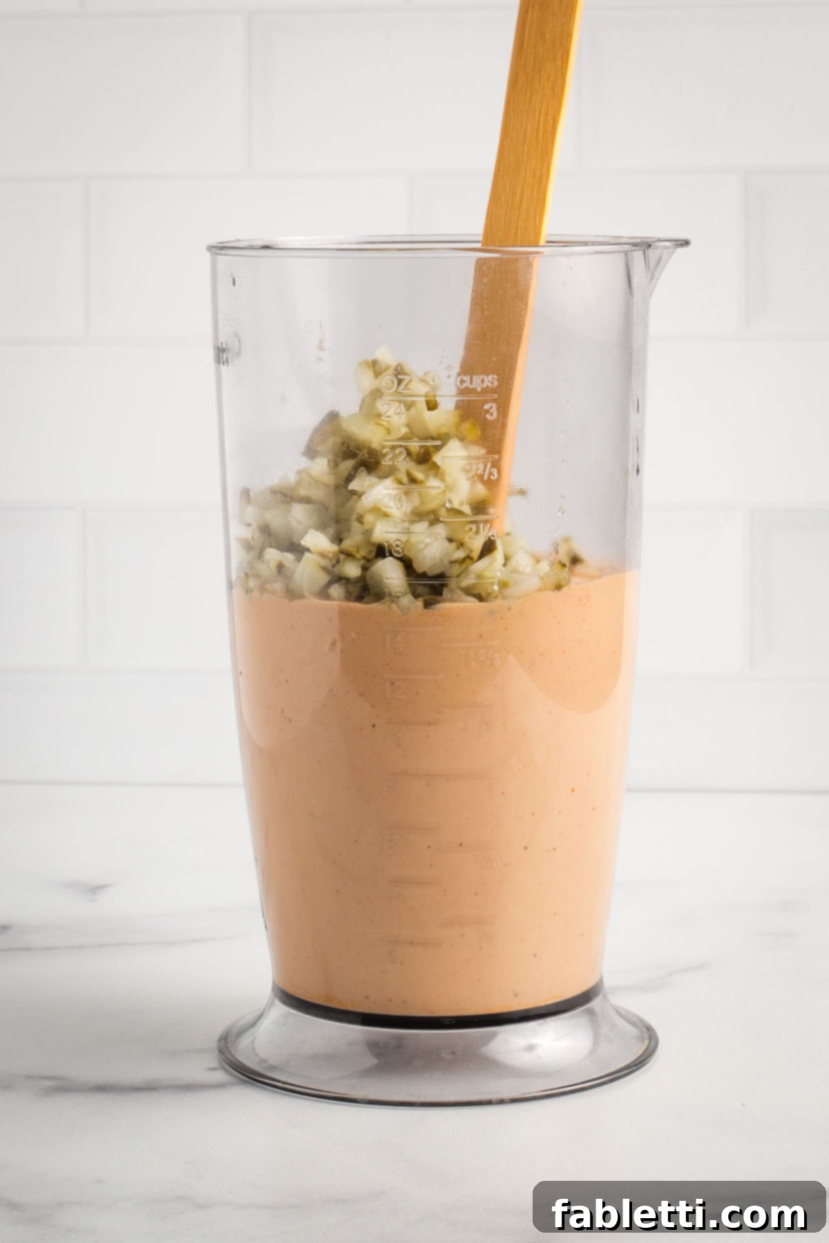 Creamy Tofu Vegan Big Mac Sauce 8 Addition of diced pickles into a tall container of burger sauce.