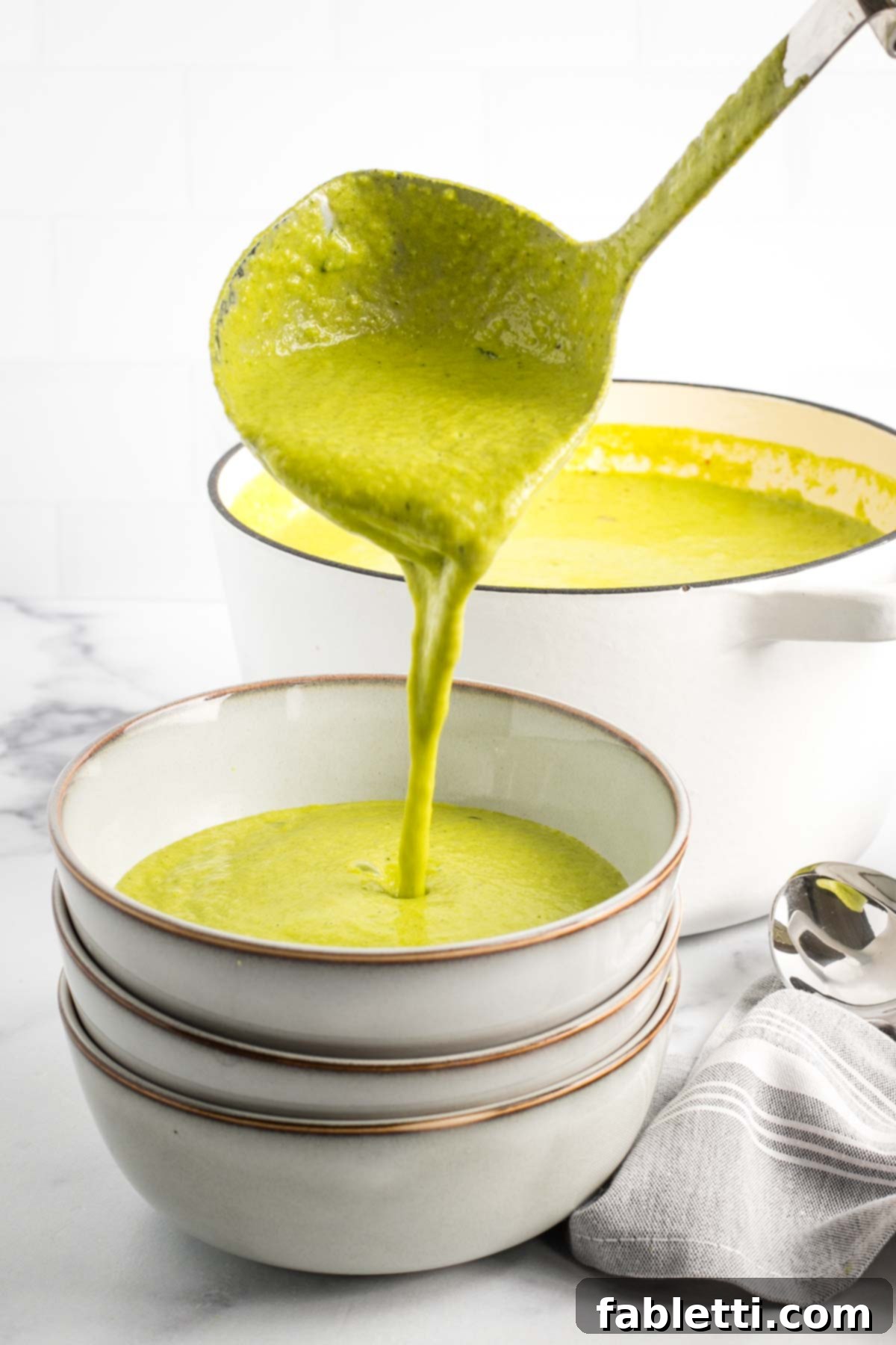 Sheet Pan Green Velvet Soup 13 Ladling thick green soup from a dutch oven into bowls.