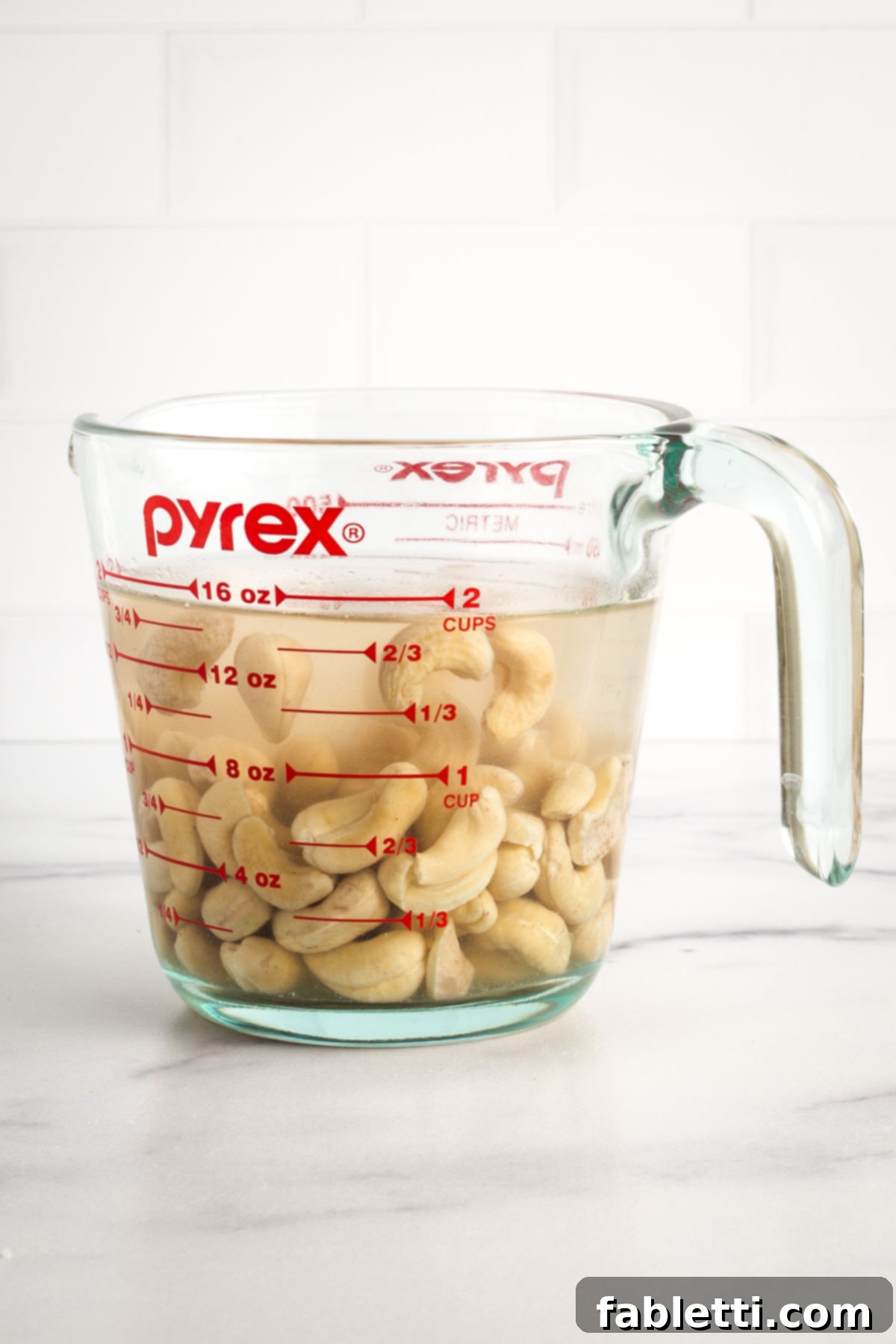 Sheet Pan Green Velvet Soup 4 Cashews covered in water in a glass measuring cup.