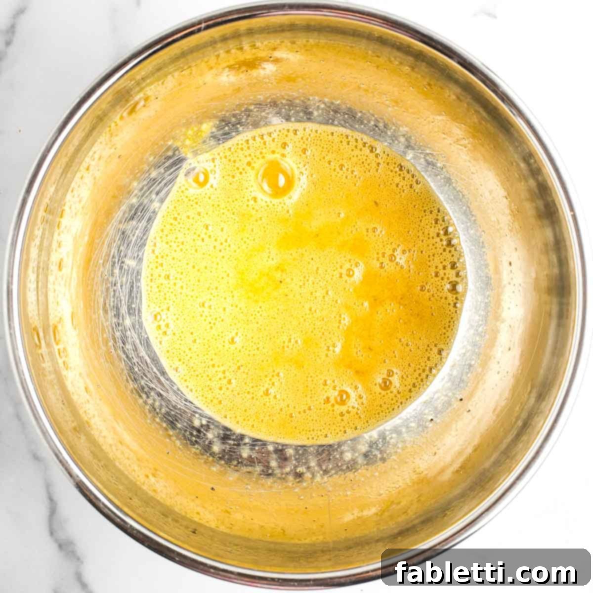 Golden Sweet Potato Kugel Cups 4 Bowl with bubbly, whisked eggs plus salt and pepper.