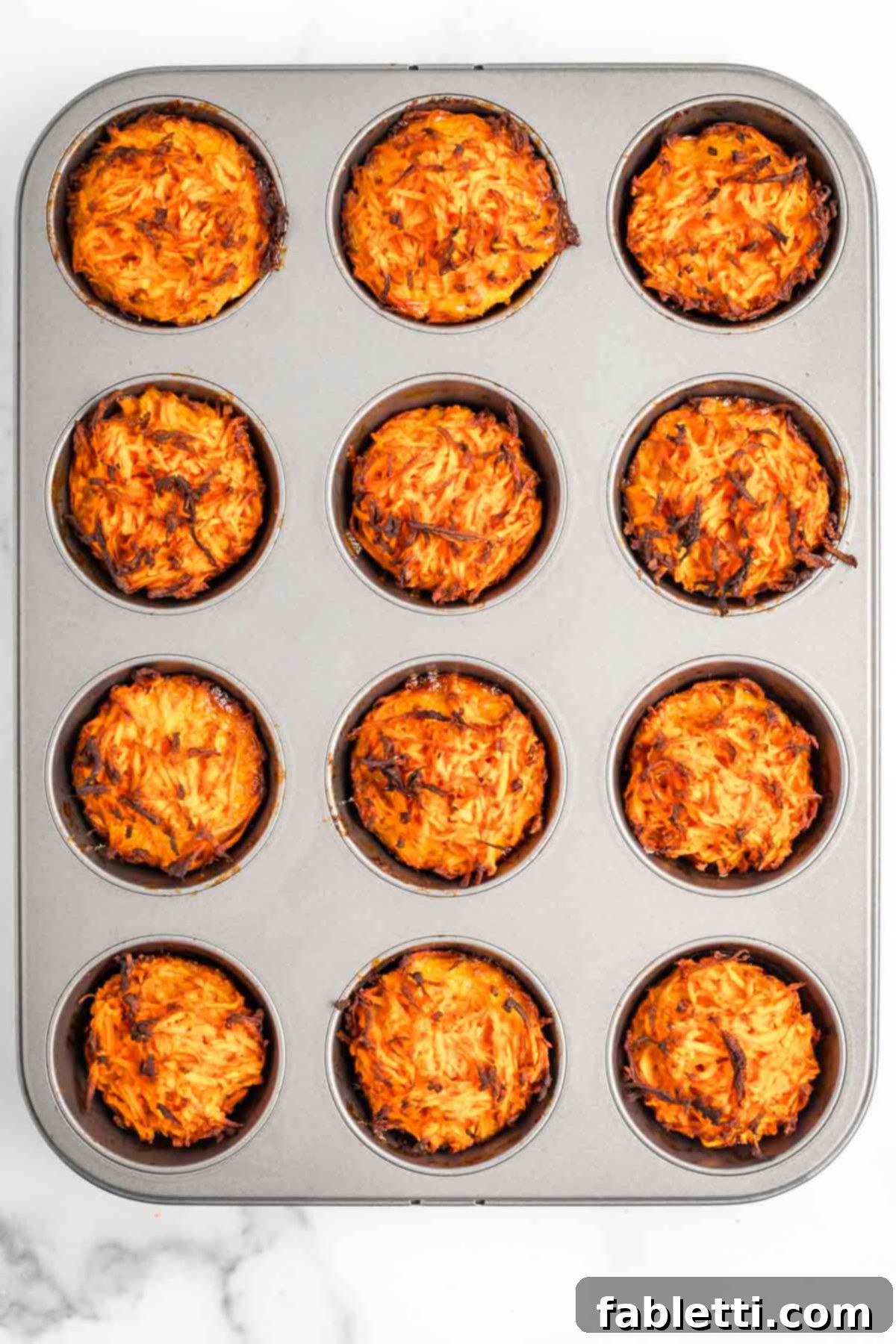 Golden Sweet Potato Kugel Cups 7 Muffin tins filled with baked and crisped sweet potato and egg mixture.