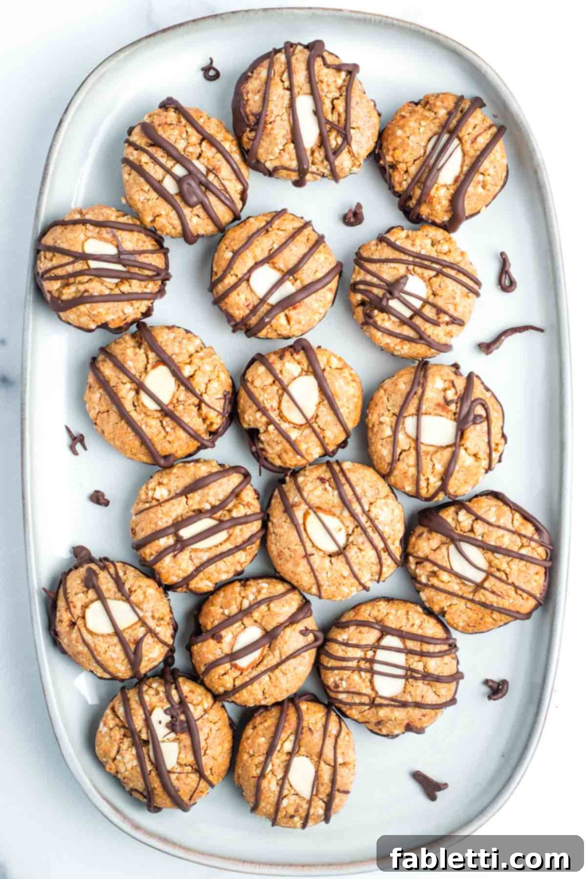 Decadent Vegan Chocolate Almond Macarons 2 Chocolate-dipped almond macaroons with chocolate drizzle and a subtle golden-brown finish.