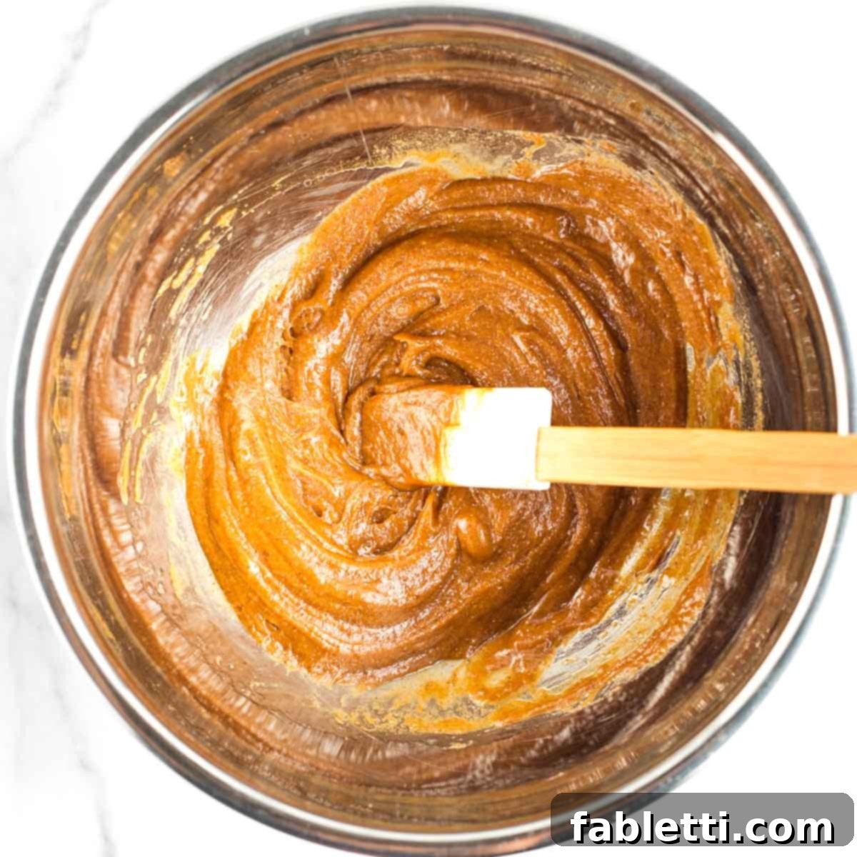 Decadent Vegan Chocolate Almond Macarons 5 Spatula stirring together wet ingredients for almond macaroons.