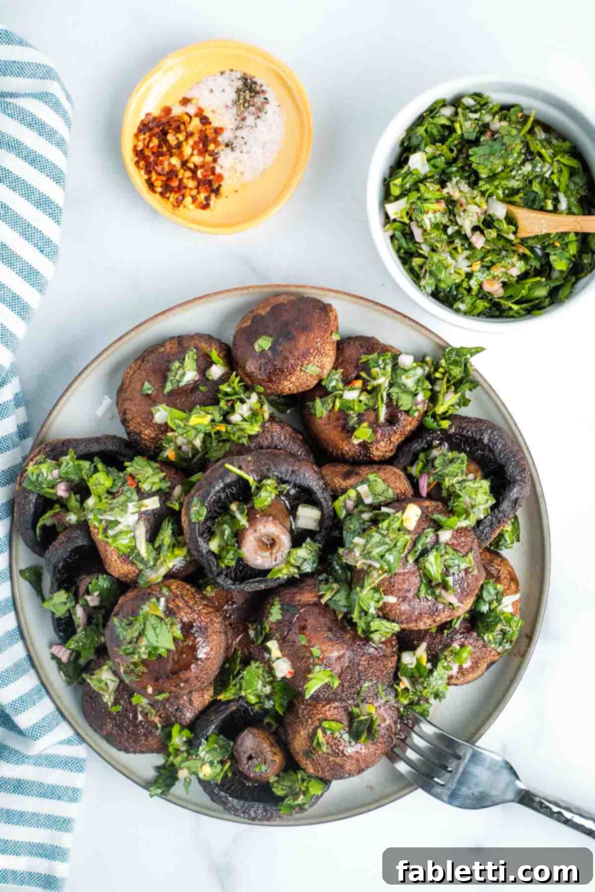 Zesty Chimichurri Portobello Steaks 2 Bowl of roasted mushrooms with bright green chimichurri sauce.